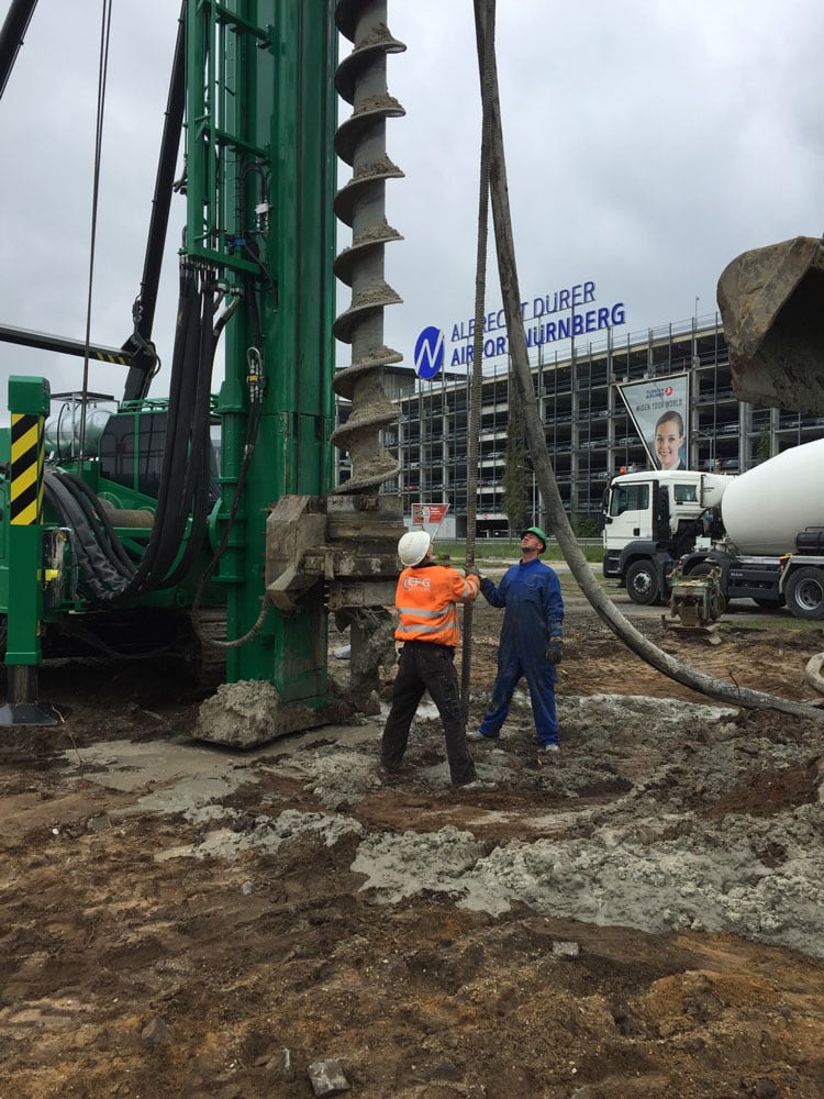 Auger on the piling rig, with the terminal of Albrecht Dürer Airport Nuremberg in the background.